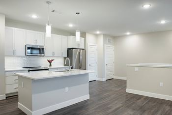 A kitchen with white cabinets and a white island